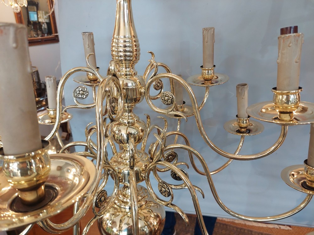 An 18th-century Dutch style polished brass chandelier featuring two tiers of curved arms, candle-style bulb holders, a central baluster stem, and a double-headed eagle crest. View II