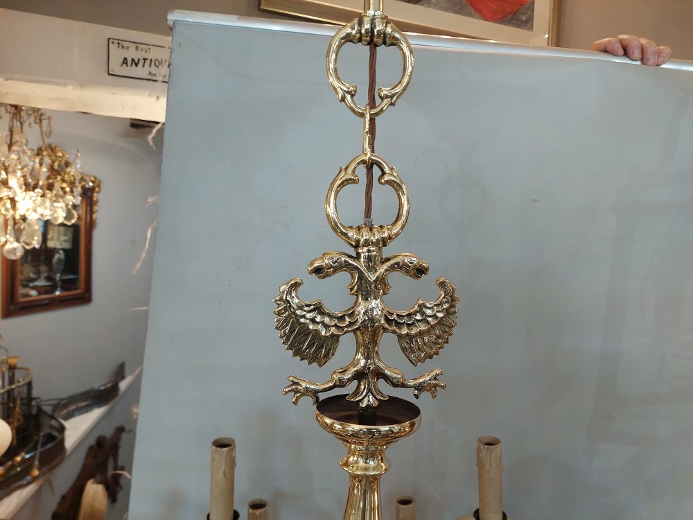 An 18th-century Dutch style polished brass chandelier featuring two tiers of curved arms, candle-style bulb holders, a central baluster stem, and a double-headed eagle crest. View III