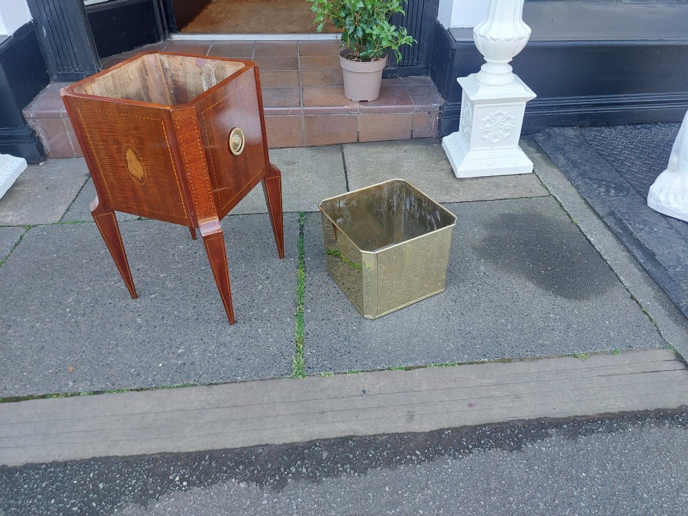 An Edwardian mahogany square jardiniere featuring satinwood line inlay, a marquetry shell motif, tapered square legs, and green foliage. View VIII