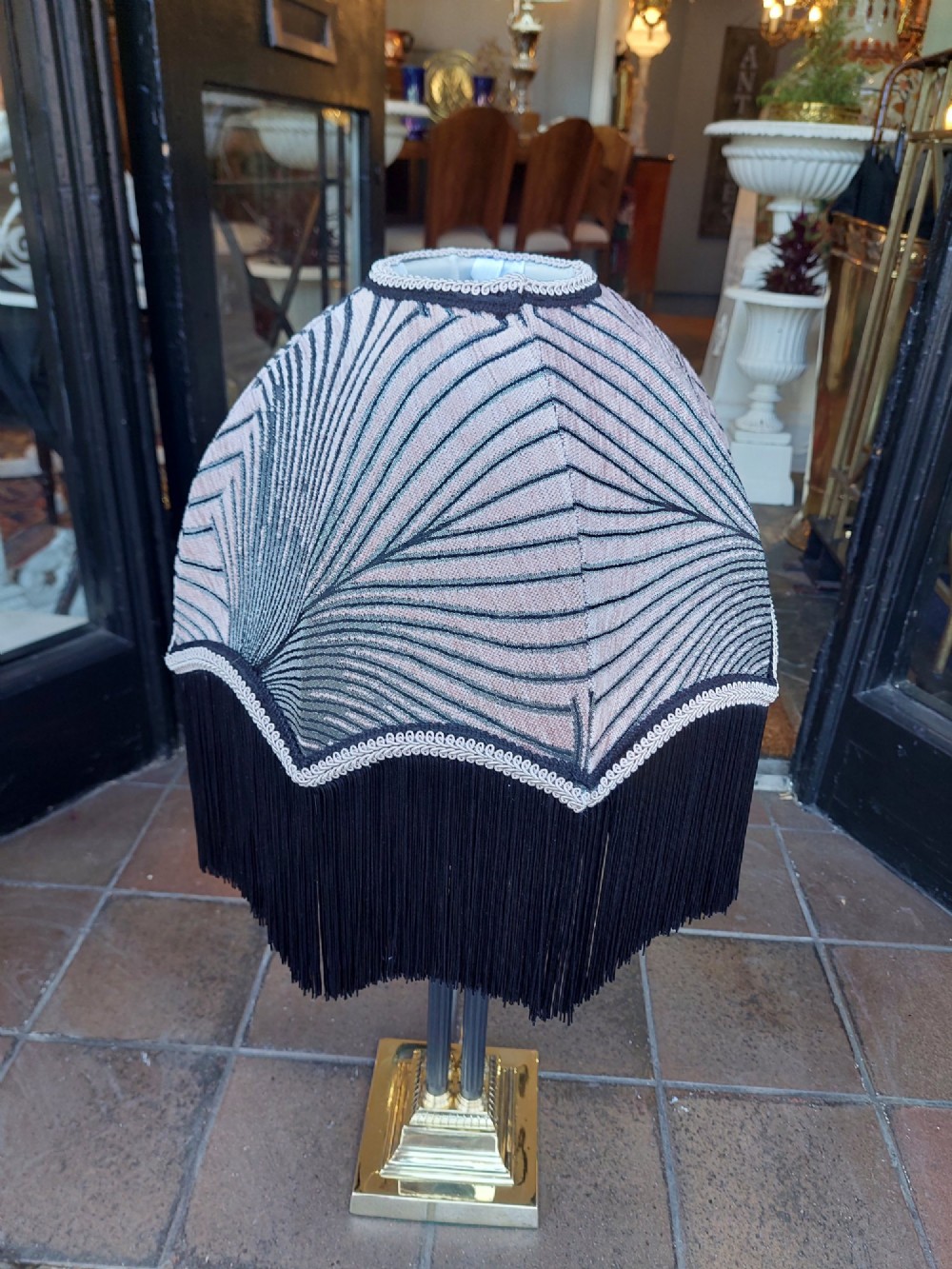 An antique brass table lamp featuring a four-pillar Corinthian column base and a patterned blue dome lampshade with dark fringe. View III