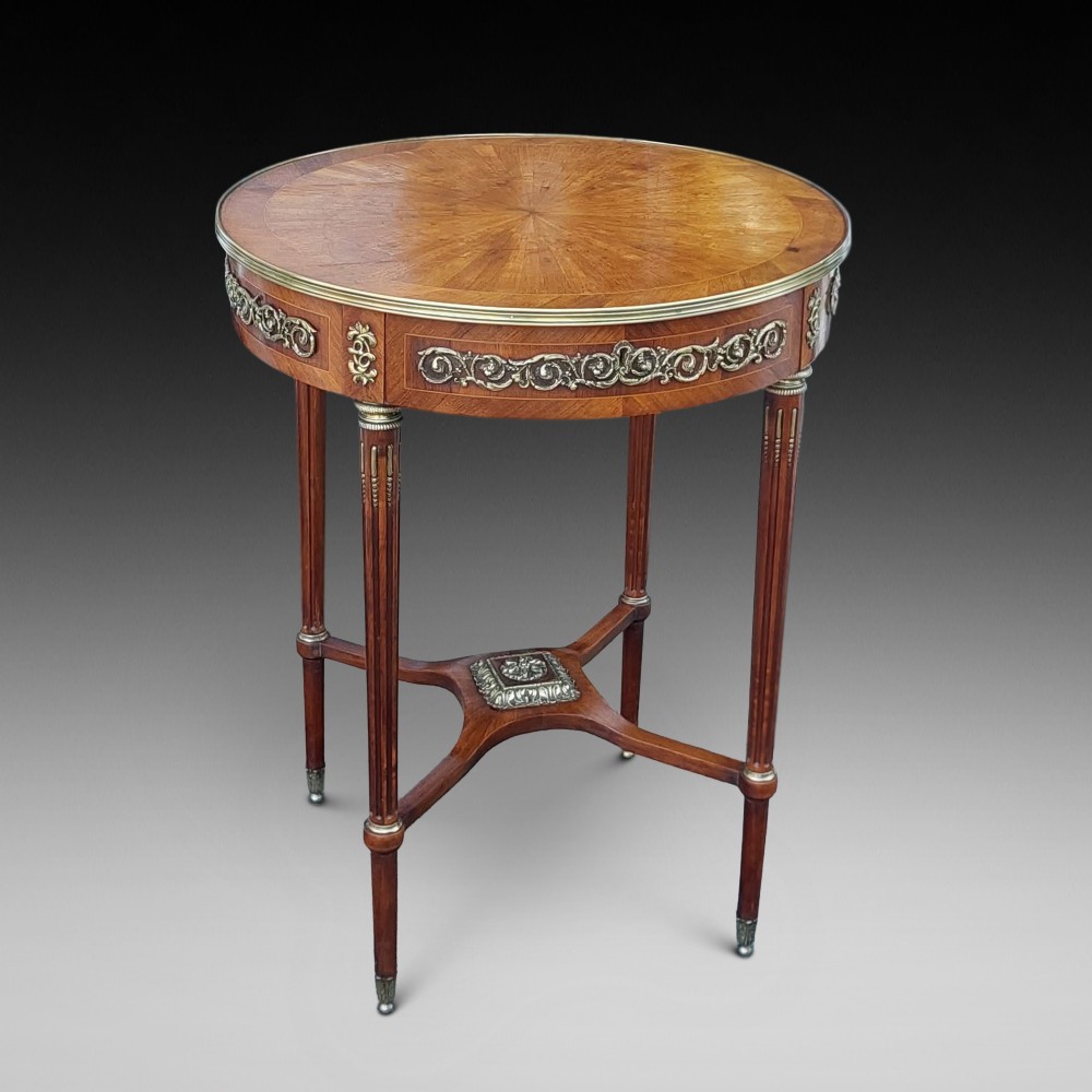 A mid-19th-century French Empire circular occasional table made of kingwood with a sunburst parquetry top and gilded metal mounts.