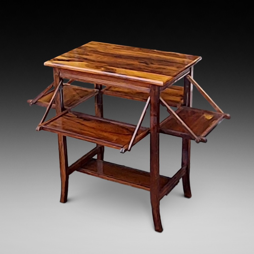 An Edwardian rosewood cake serving table featuring multiple drop-down folding side shelves and a polished rectangular top.
