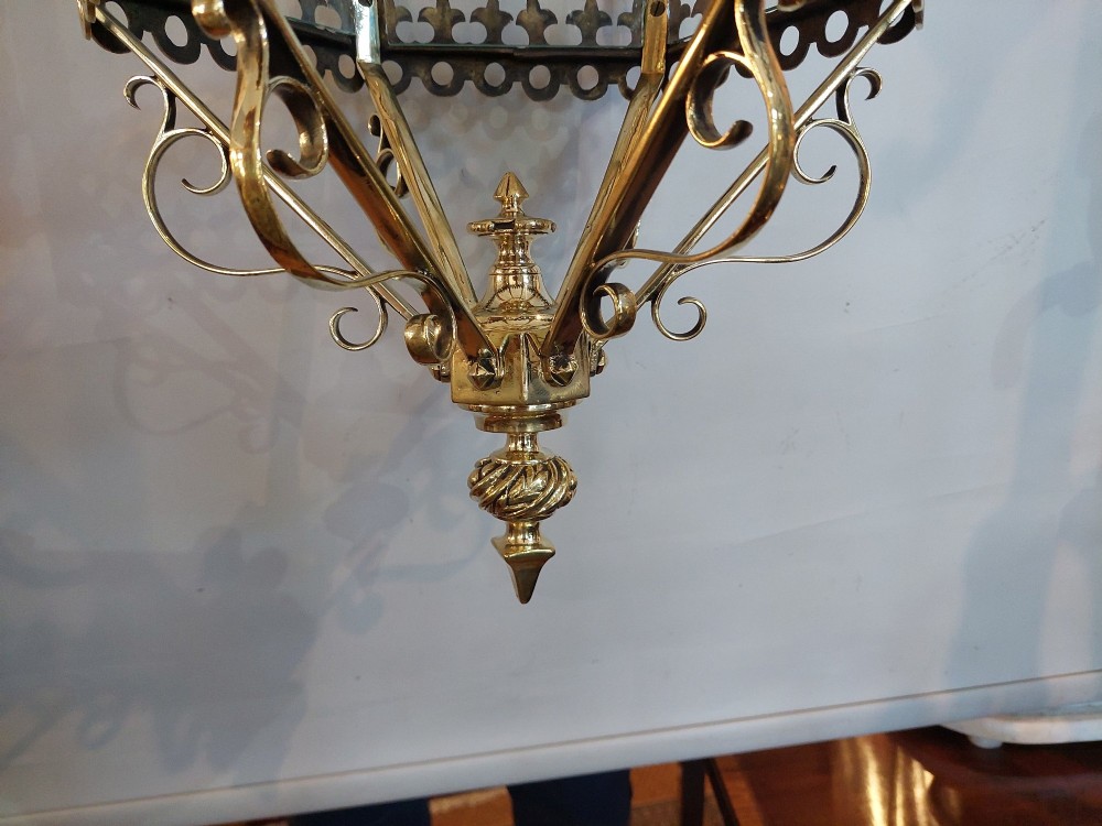 A hexagonal Victorian hanging brass lantern featuring glass panels, twisted corner columns, decorative scrollwork, and a central light bulb fitting. View VII