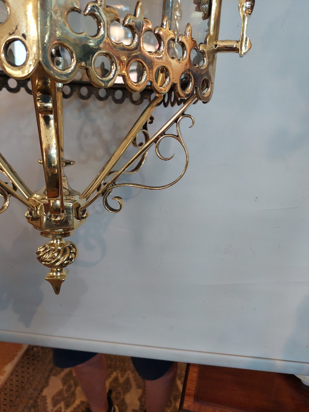 A hexagonal Victorian hanging brass lantern featuring glass panels, twisted corner columns, decorative scrollwork, and a central light bulb fitting. View VIII