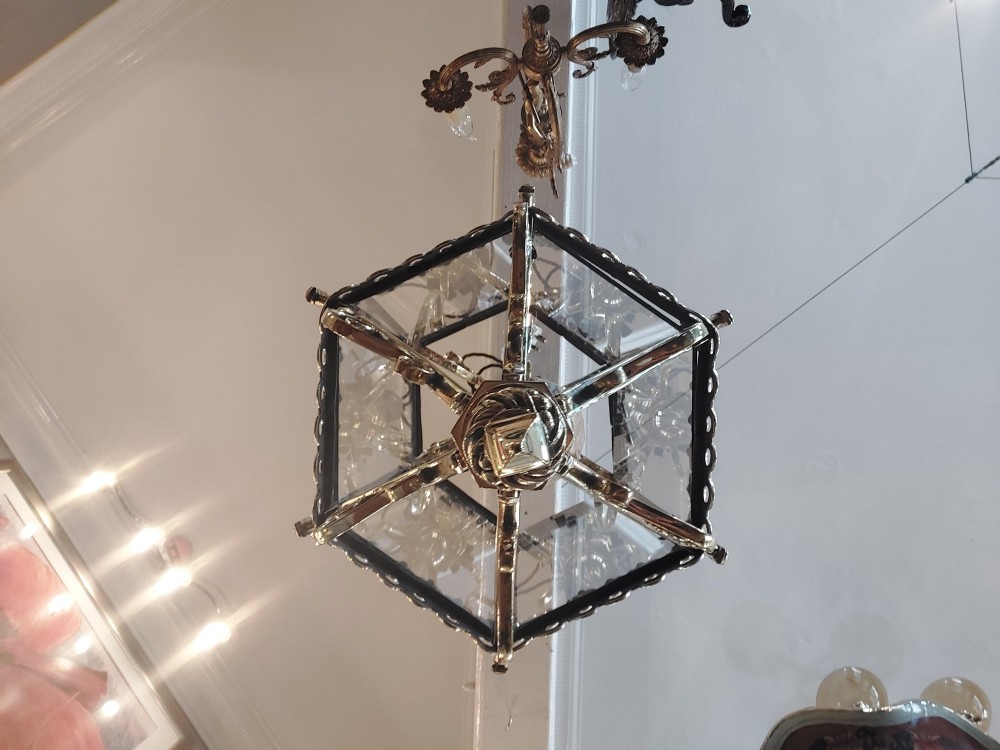 A hexagonal Victorian hanging brass lantern featuring glass panels, twisted corner columns, decorative scrollwork, and a central light bulb fitting. View X
