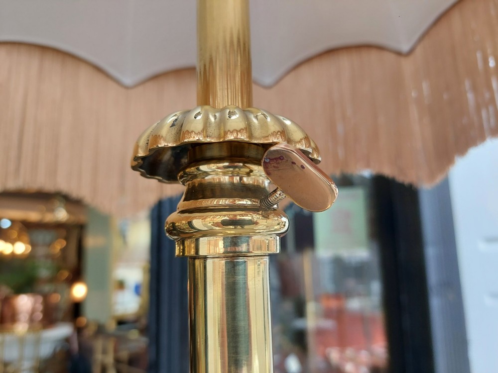 A Victorian brass standard floor lamp featuring a fluted column base and a scalloped green floral fabric shade with tassel fringe. View VIII