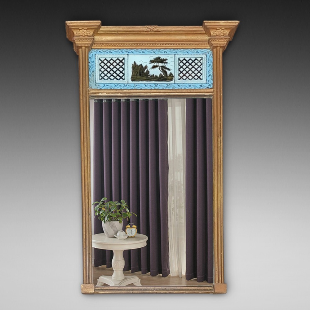 A Regency giltwood pier mirror featuring an architectural cornice, fluted side pilasters, and a blue verre eglomise glass frieze with a landscape scene.