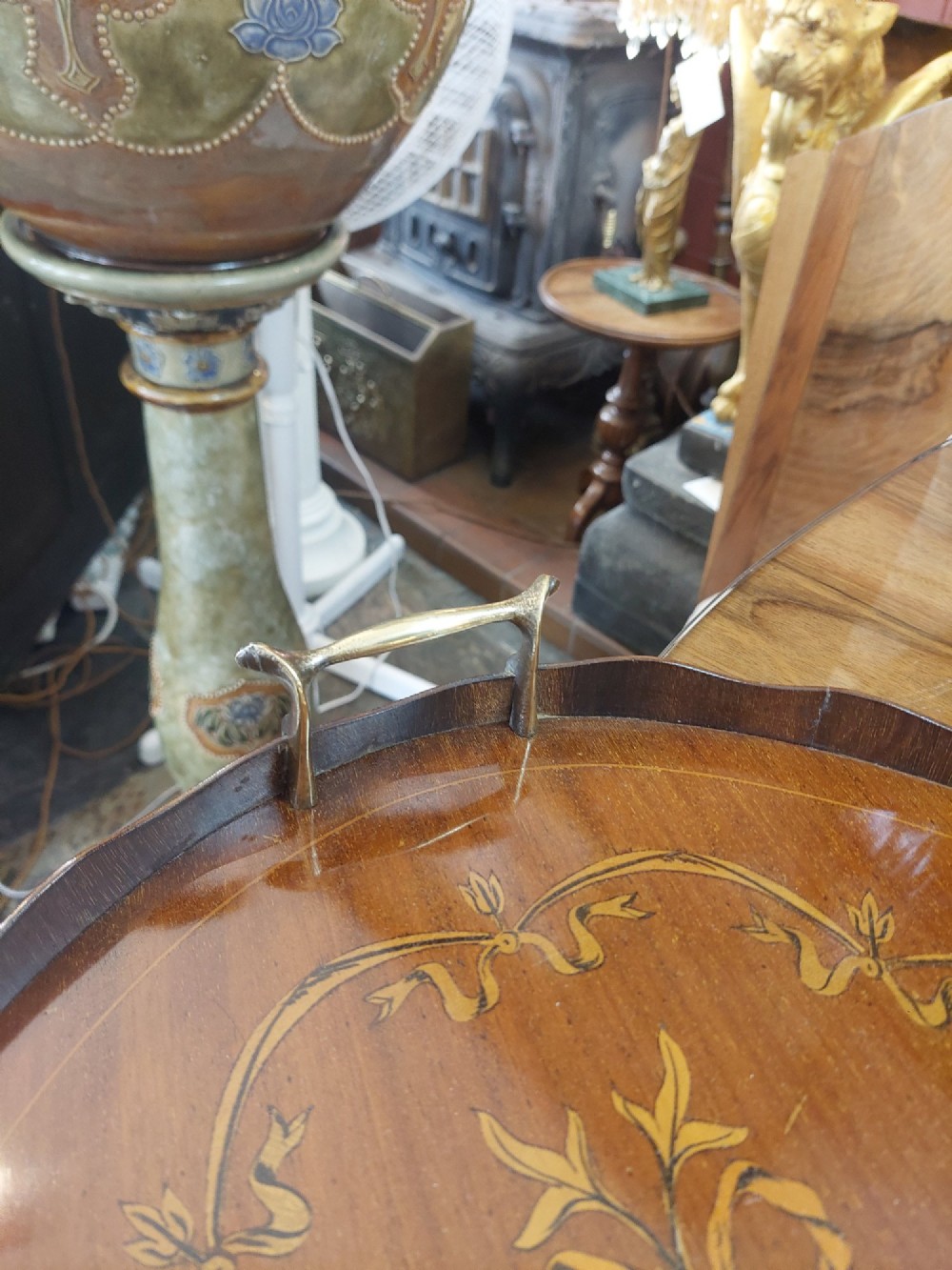 An oval mahogany tray featuring detailed floral and bow marquetry inlays, a scalloped gallery edge, and two brass side handles. View III