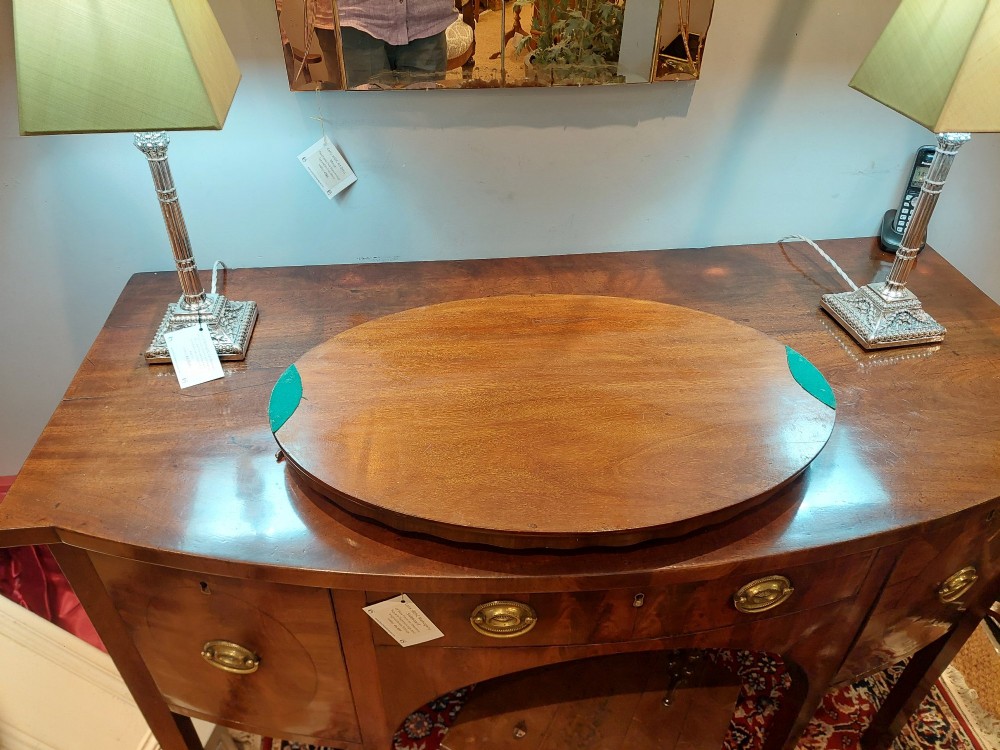 An oval mahogany tray featuring detailed floral and bow marquetry inlays, a scalloped gallery edge, and two brass side handles. View V