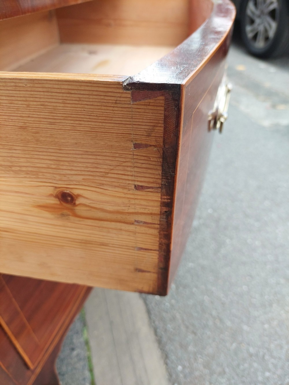 A Regency mahogany bow front chest featuring two short over two long drawers with oval brass handles, inlaid stringing, and splayed bracket feet. View IV