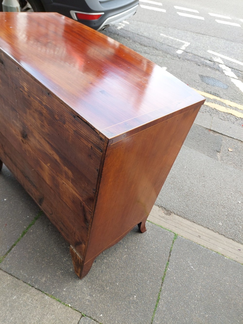 A Regency mahogany bow front chest featuring two short over two long drawers with oval brass handles, inlaid stringing, and splayed bracket feet. View VI