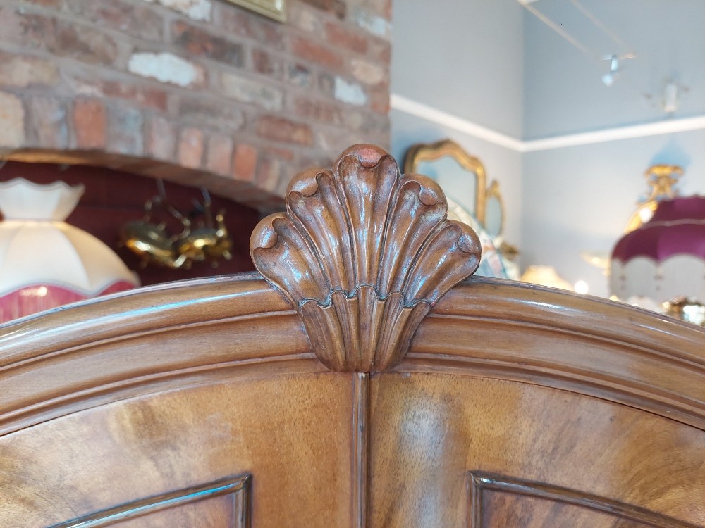 A mid-20th-century flame walnut drinks cabinet featuring double doors, carved shell motifs, and cabriole legs. View III
