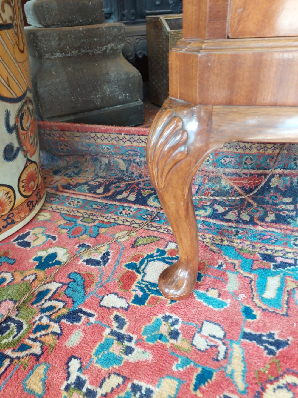 A mid-20th-century flame walnut drinks cabinet featuring double doors, carved shell motifs, and cabriole legs. View V