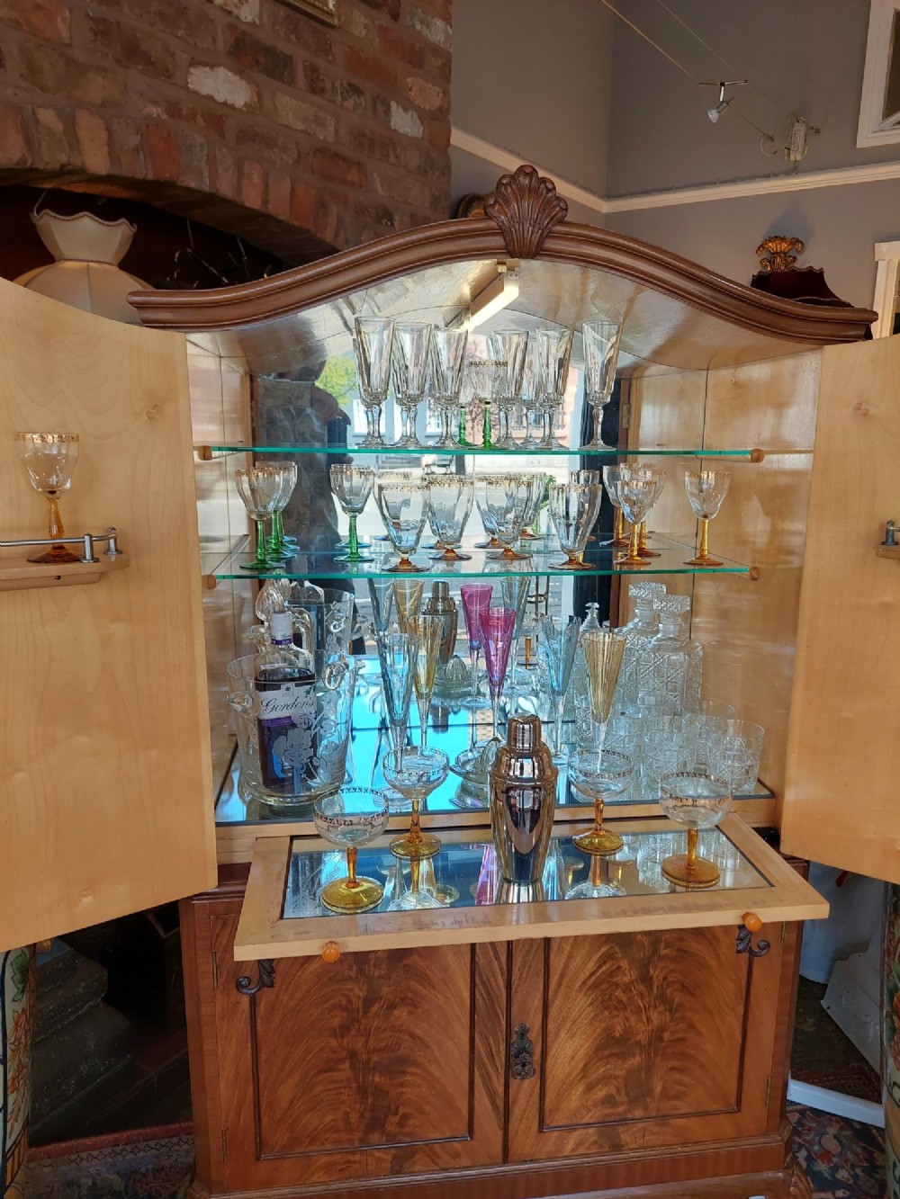 A mid-20th-century flame walnut drinks cabinet featuring double doors, carved shell motifs, and cabriole legs. View VIII