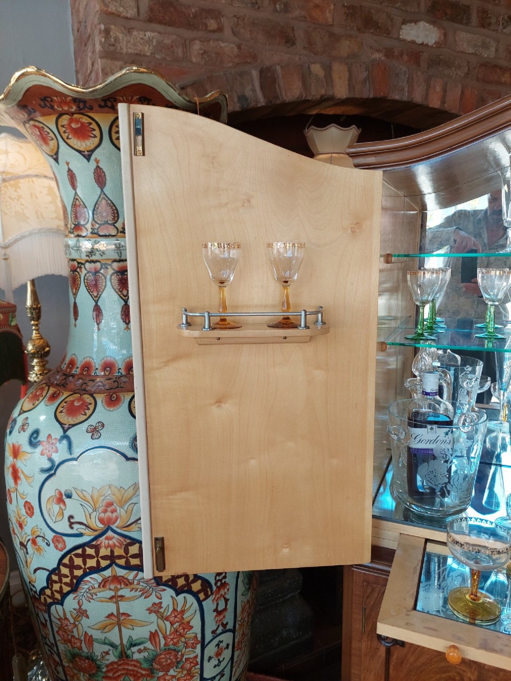 A mid-20th-century flame walnut drinks cabinet featuring double doors, carved shell motifs, and cabriole legs. View IX