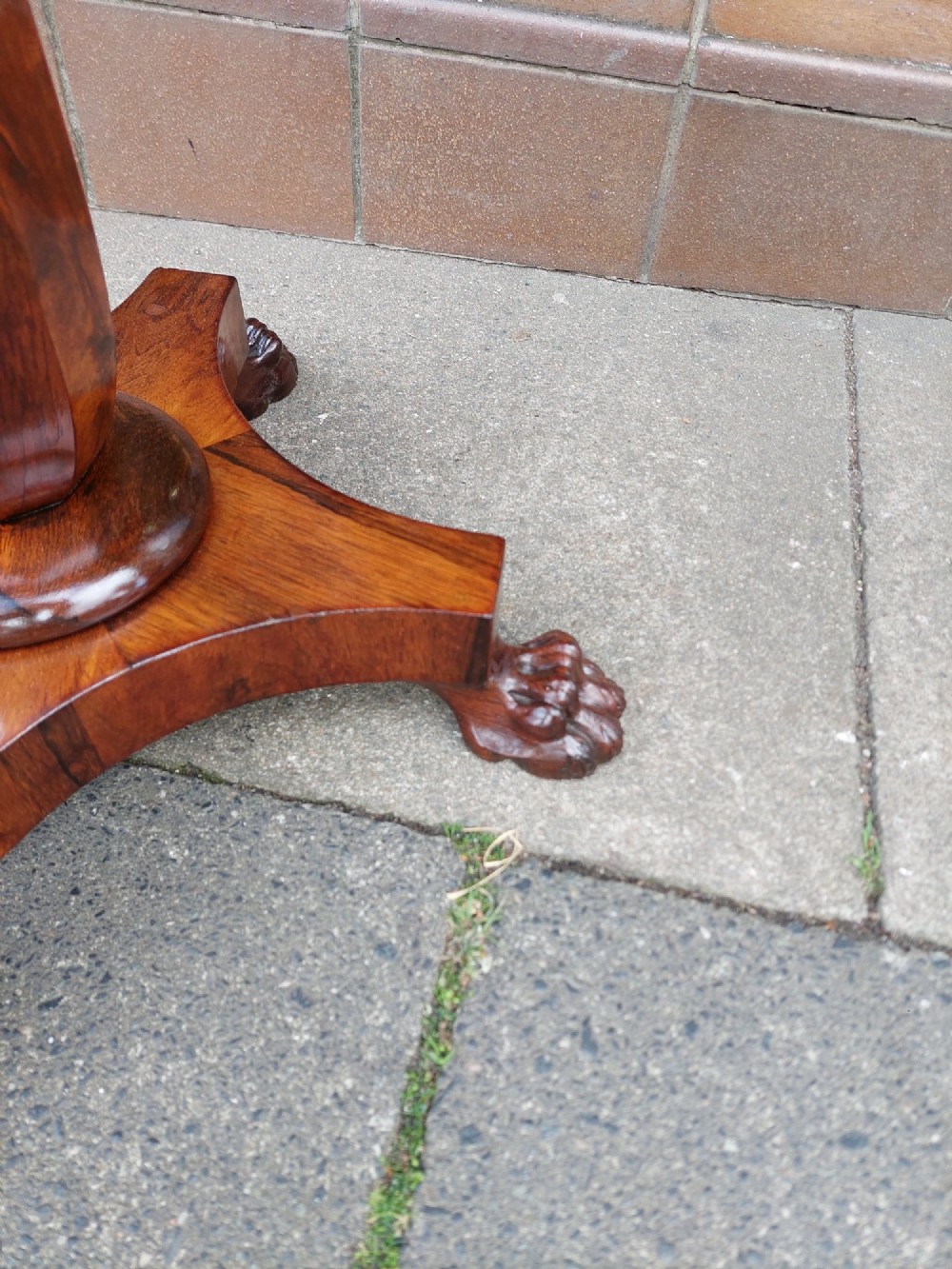 An antique William IV octagonal rosewood occasional table featuring a segmented veneer top, scalloped apron with drop finials, turned pedestal stem, and quadruped base with carved claw feet. View III