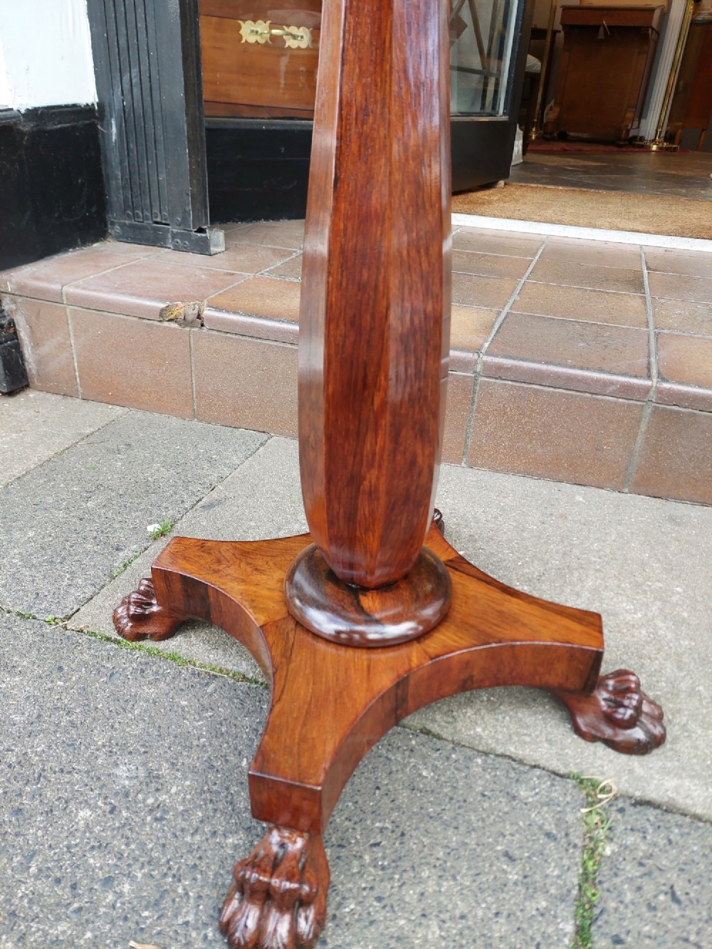 An antique William IV octagonal rosewood occasional table featuring a segmented veneer top, scalloped apron with drop finials, turned pedestal stem, and quadruped base with carved claw feet. View V
