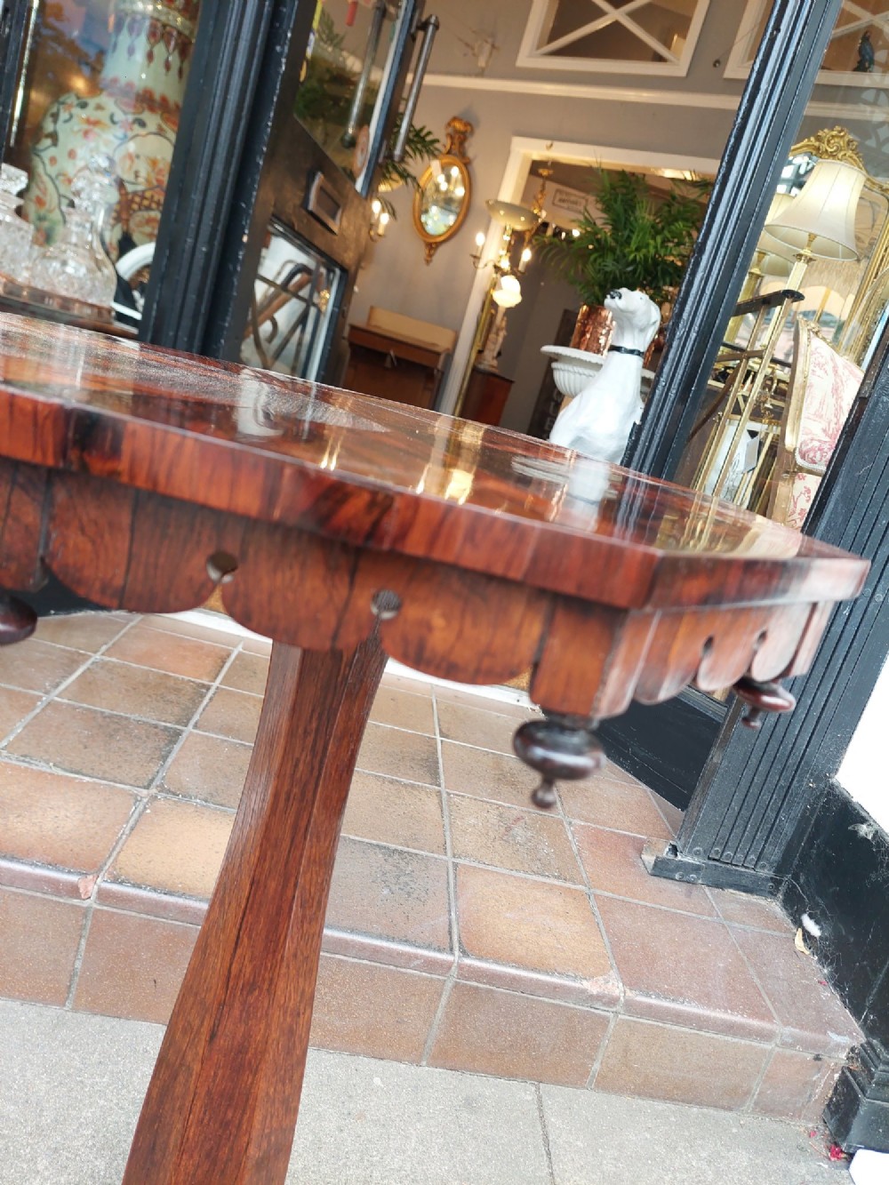 An antique William IV octagonal rosewood occasional table featuring a segmented veneer top, scalloped apron with drop finials, turned pedestal stem, and quadruped base with carved claw feet. View VI