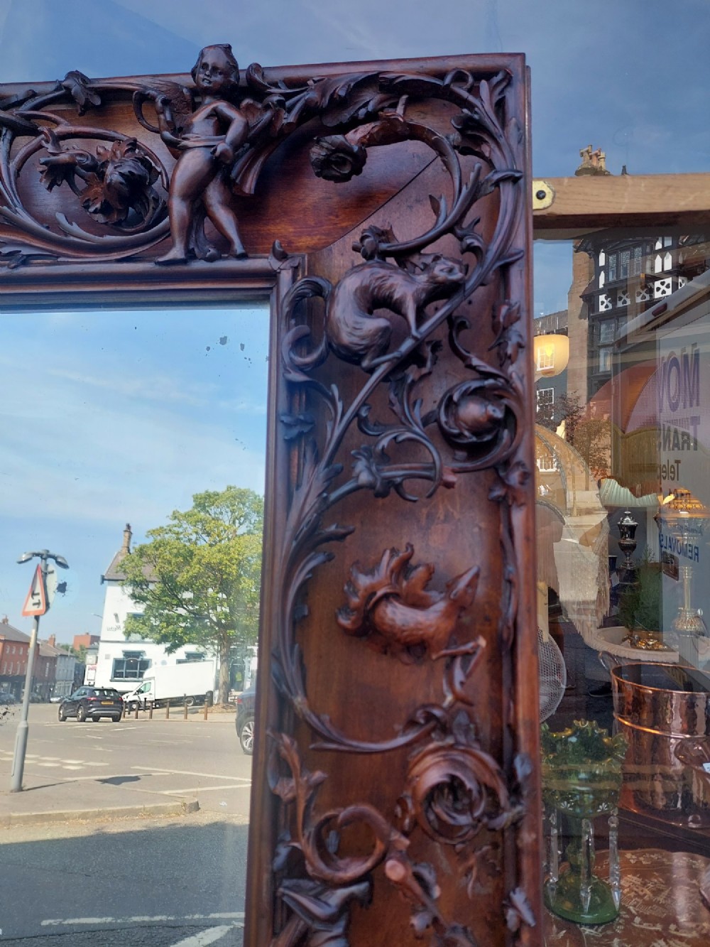 A large rectangular Victorian wall mirror set within a deeply carved dark walnut frame adorned with cherub figures and foliate relief details. View II