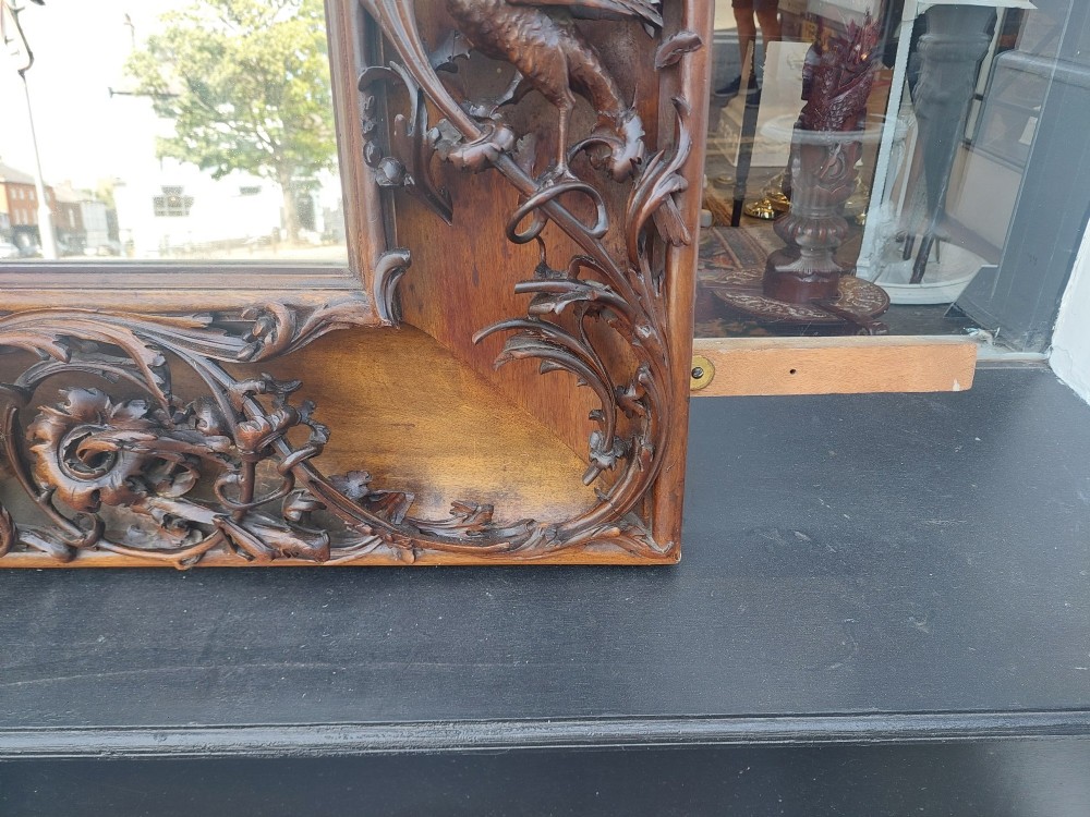 A large rectangular Victorian wall mirror set within a deeply carved dark walnut frame adorned with cherub figures and foliate relief details. View IV