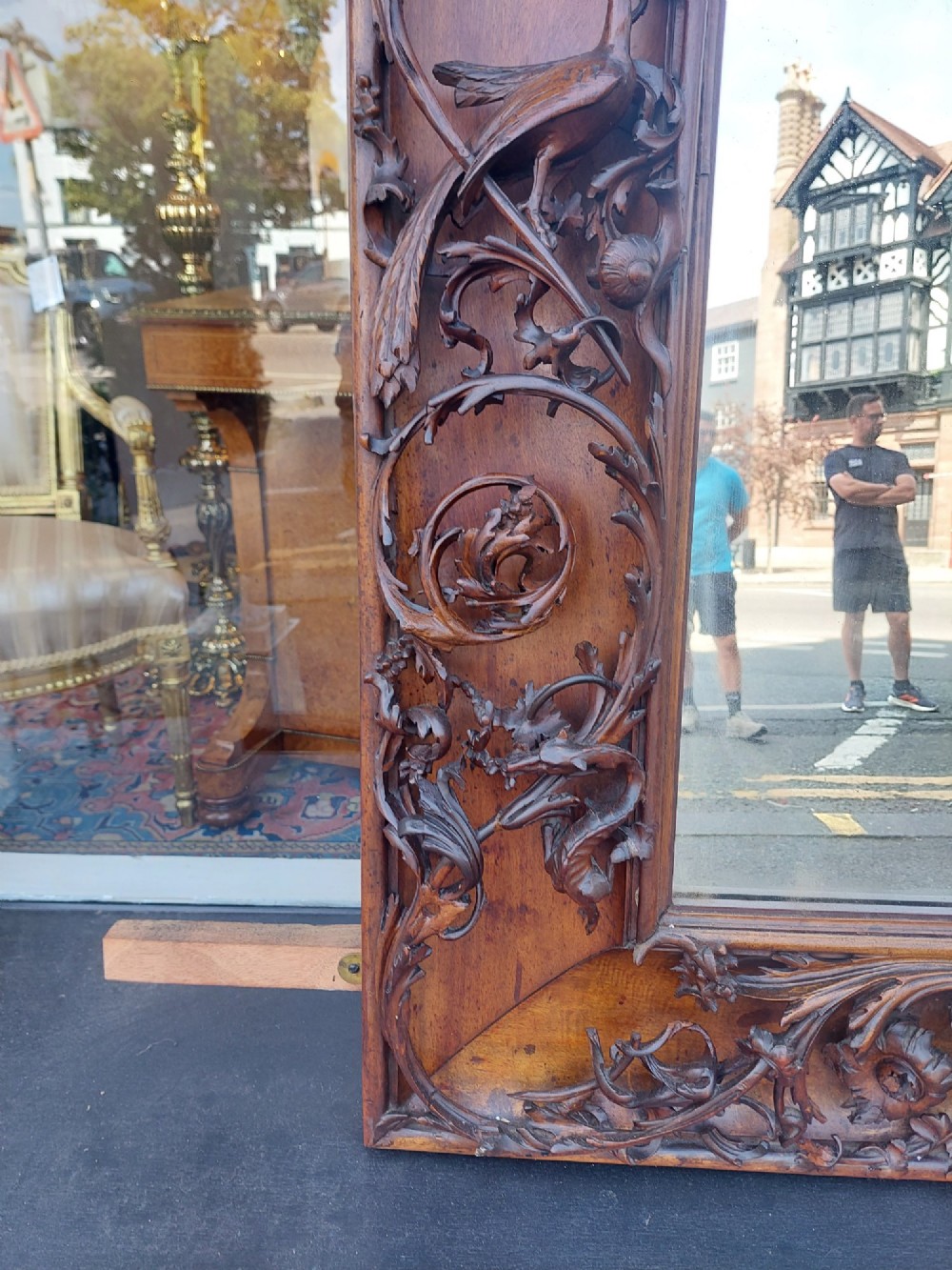 A large rectangular Victorian wall mirror set within a deeply carved dark walnut frame adorned with cherub figures and foliate relief details. View VIII