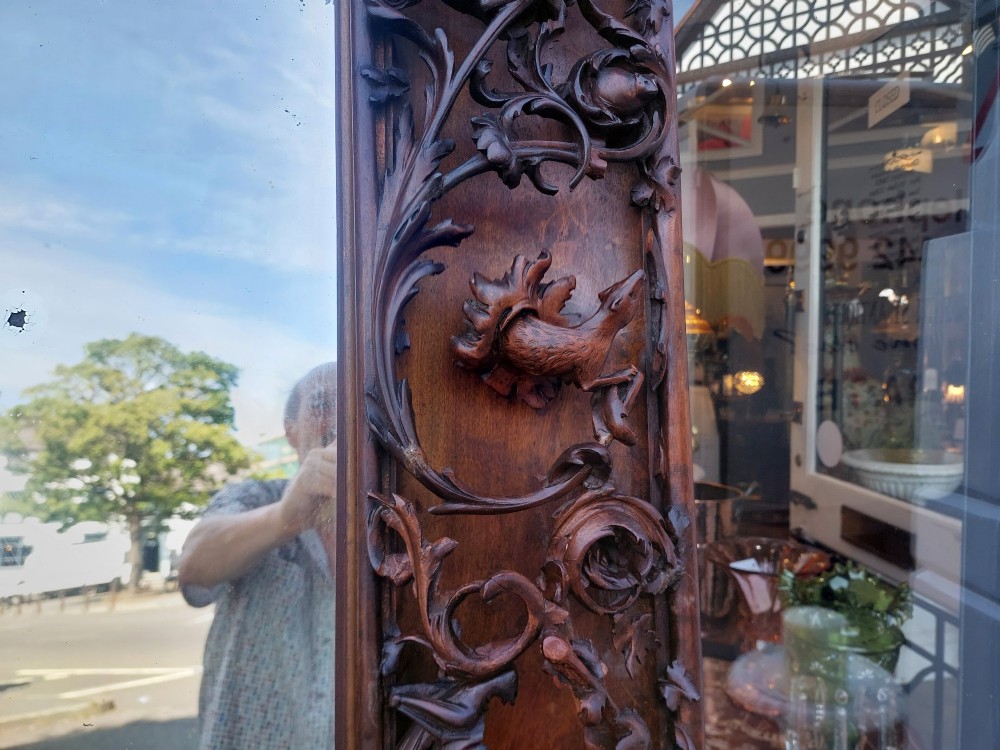 A large rectangular Victorian wall mirror set within a deeply carved dark walnut frame adorned with cherub figures and foliate relief details. View XIII