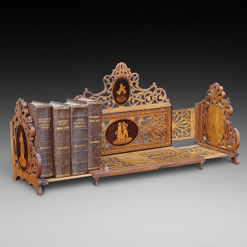 A late nineteenth-century Sorrento olive wood extending book rack featuring pierced fretwork, scroll borders, and central oval panels with inlaid figures. View III