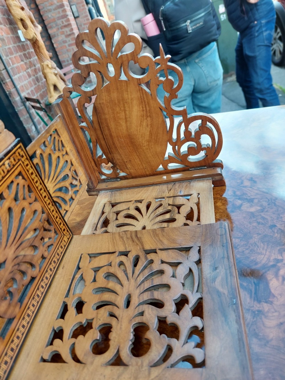 A late nineteenth-century Sorrento olive wood extending book rack featuring pierced fretwork, scroll borders, and central oval panels with inlaid figures. View V