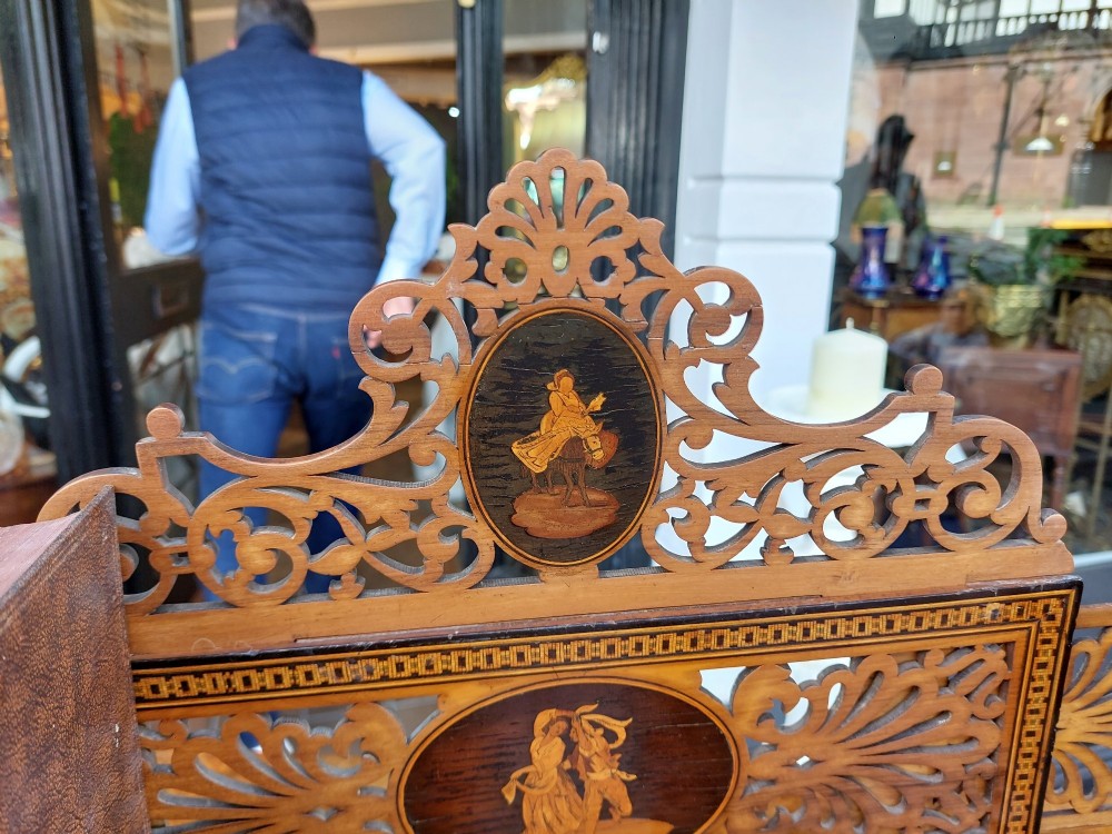 A late nineteenth-century Sorrento olive wood extending book rack featuring pierced fretwork, scroll borders, and central oval panels with inlaid figures. View VII