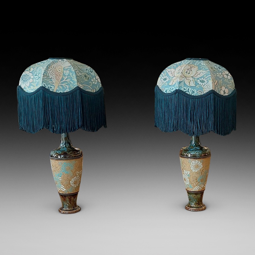 A pair of Royal Doulton Slaters Patent stoneware table lamps featuring patterned blue and gold ceramic bases paired with matching floral fringed fabric shades.