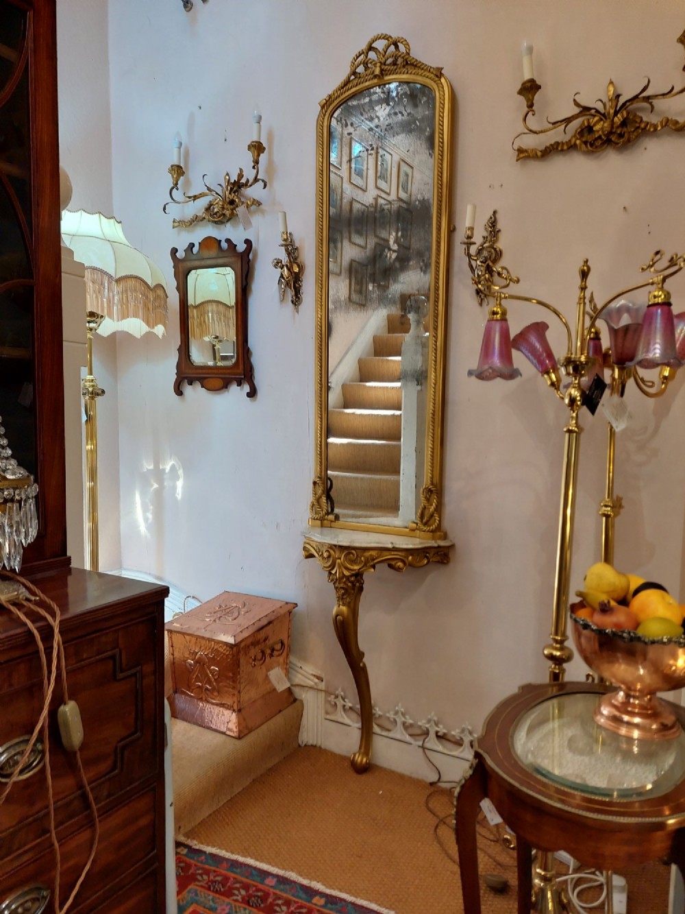 A tall late 19th-century French gilt gesso pier mirror featuring a rope-twist border and top ribbon motif, mounted above a small marble-topped single-leg console. View II
