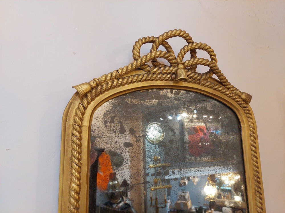 A tall late 19th-century French gilt gesso pier mirror featuring a rope-twist border and top ribbon motif, mounted above a small marble-topped single-leg console. View IV