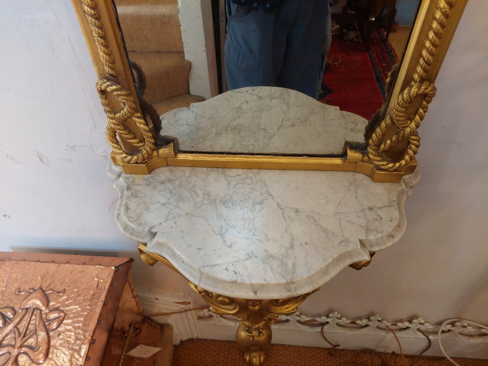 A tall late 19th-century French gilt gesso pier mirror featuring a rope-twist border and top ribbon motif, mounted above a small marble-topped single-leg console. View VI