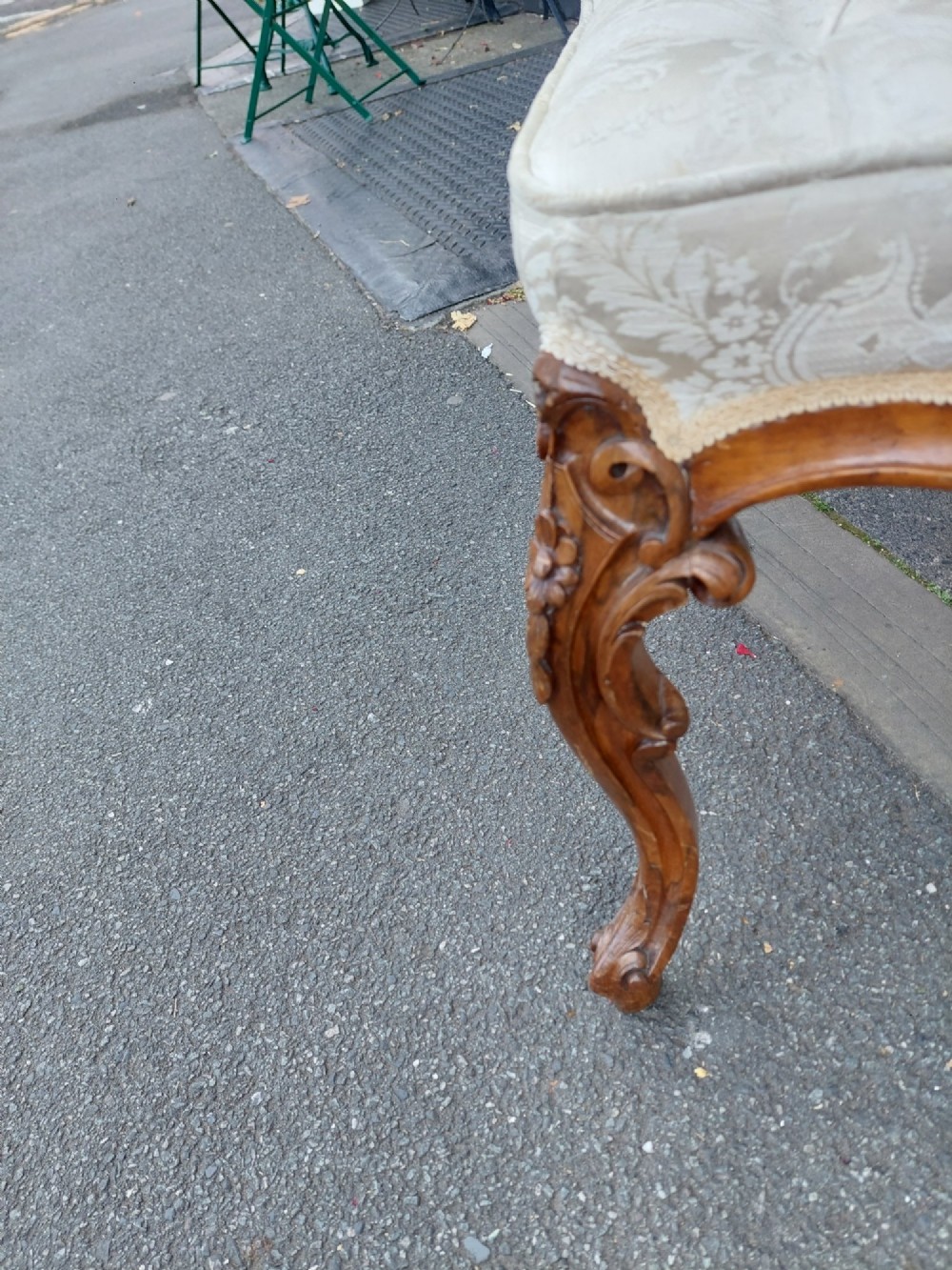 A Victorian walnut stool featuring carved cabriole legs, a serpentine apron, and a cream button-tufted upholstered top. View II