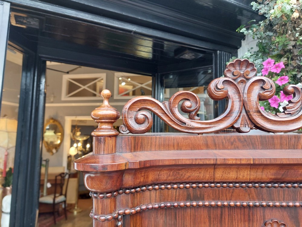 A two-tier Biedermeier rosewood display cabinet featuring a glazed upper section with a carved cresting above a two-door cupboard base. View IV