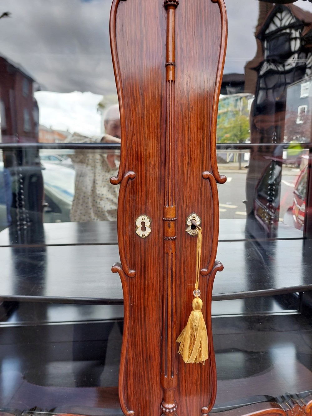 A two-tier Biedermeier rosewood display cabinet featuring a glazed upper section with a carved cresting above a two-door cupboard base. View V