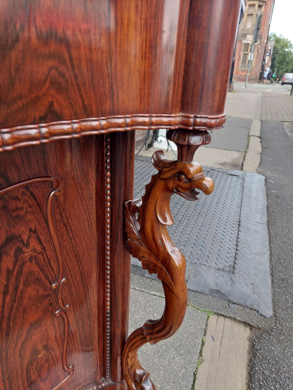 A two-tier Biedermeier rosewood display cabinet featuring a glazed upper section with a carved cresting above a two-door cupboard base. View X