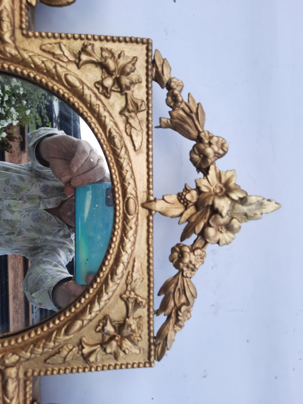 A late nineteenth-century three-panel gilt wall mirror featuring an arched central plate, intricate carved floral cresting, and an integrated base shelf. View V
