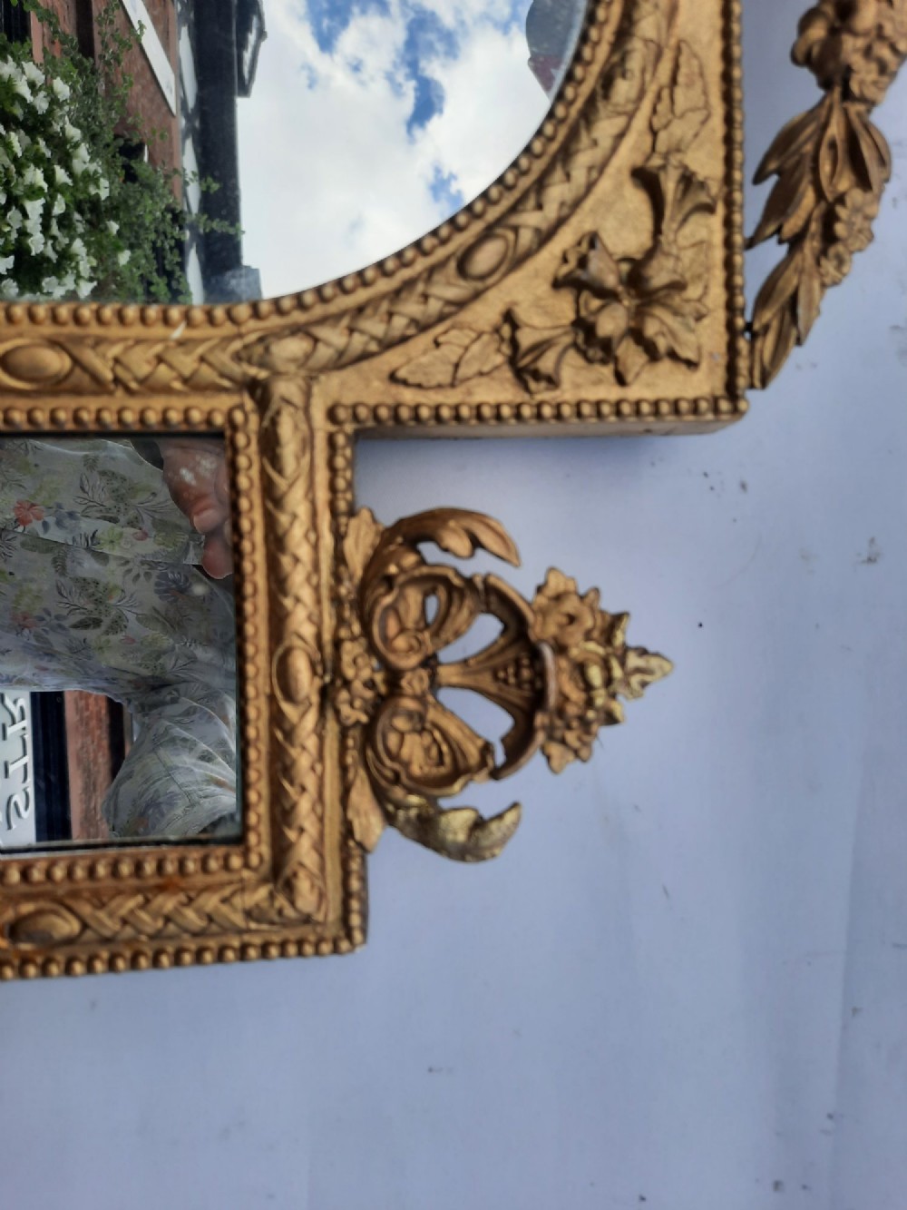 A late nineteenth-century three-panel gilt wall mirror featuring an arched central plate, intricate carved floral cresting, and an integrated base shelf. View VI