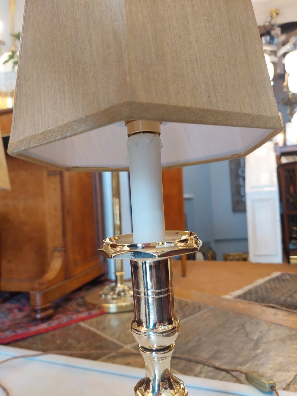 A pair of polished Victorian brass candlestick table lamps fitted with hexagonal beige fabric shades. View VII