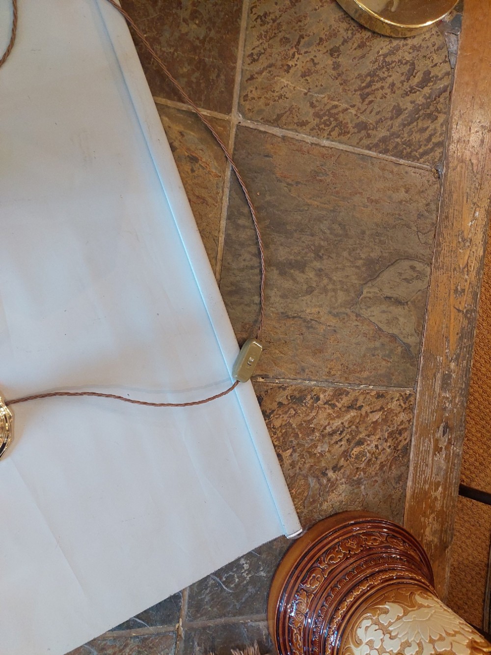 A pair of polished Victorian brass candlestick table lamps fitted with hexagonal beige fabric shades. View VIII