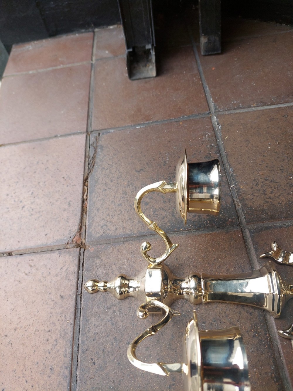 A pair of polished brass double-arm wall sconces featuring ribbon bow top motifs, urn-shaped central stems, and scrolling candle branches. View VII