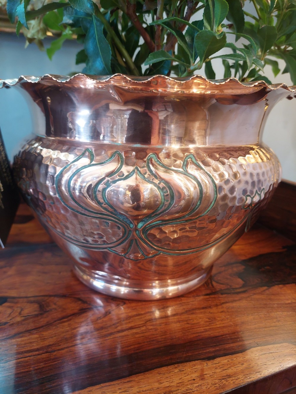 An Edwardian Art Nouveau copper planter featuring a hand-hammered texture, embossed leaf motifs, and a crimped rim. View II