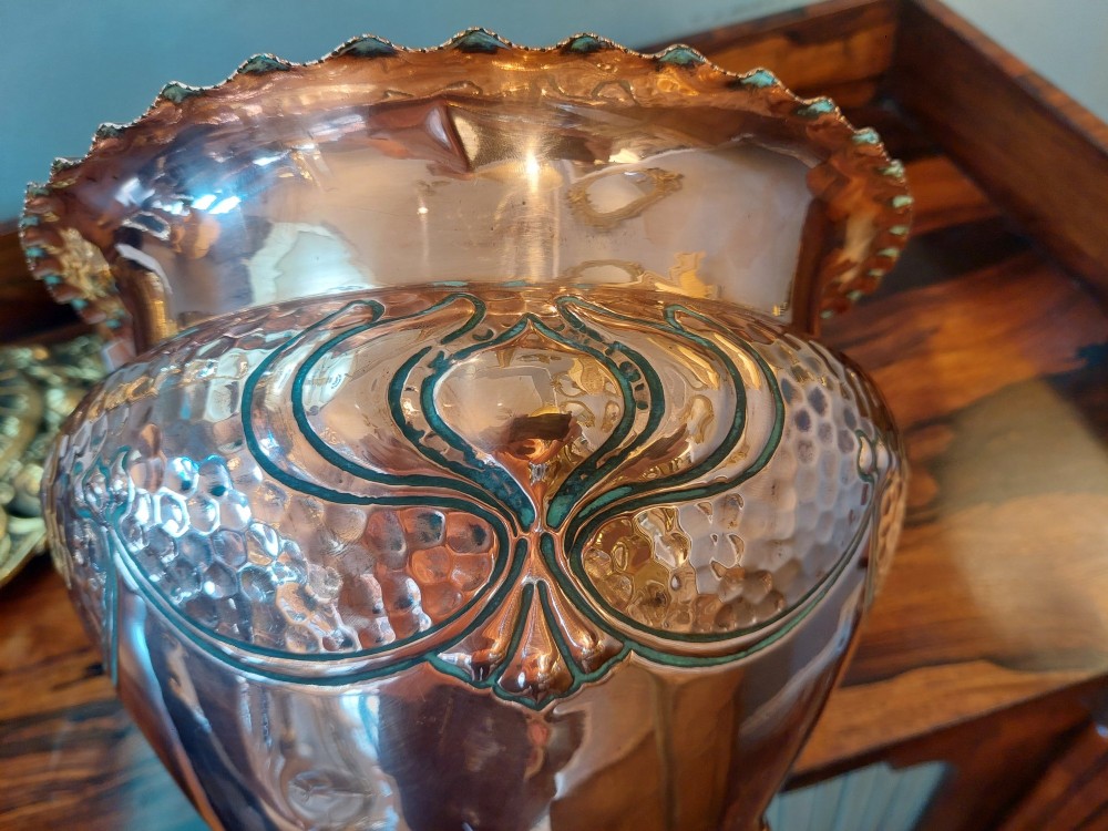 An Edwardian Art Nouveau copper planter featuring a hand-hammered texture, embossed leaf motifs, and a crimped rim. View V