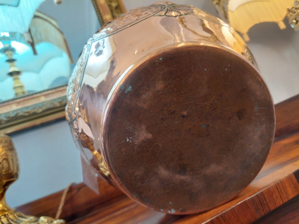 An Edwardian Art Nouveau copper planter featuring a hand-hammered texture, embossed leaf motifs, and a crimped rim. View VII