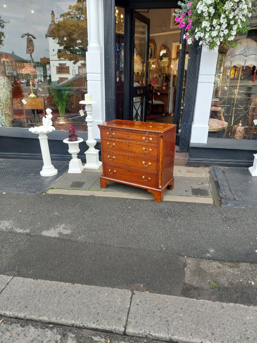 A George III mahogany bachelors chest featuring four graduated drawers, brass swan-neck handles, an upper pull-out brushing slide, and classic bracket feet. View II