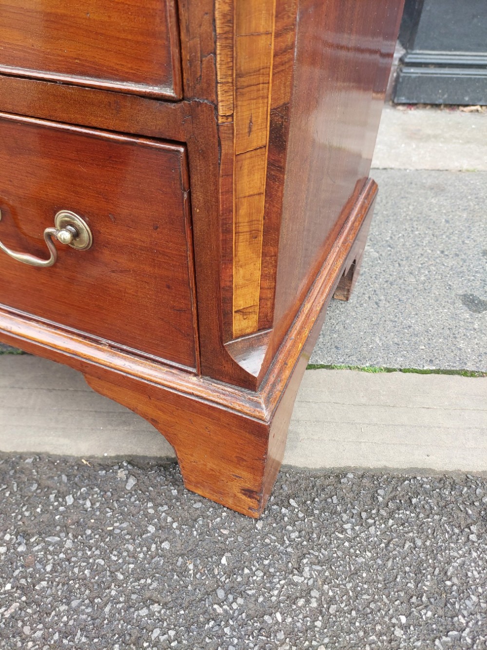 A George III mahogany bachelors chest featuring four graduated drawers, brass swan-neck handles, an upper pull-out brushing slide, and classic bracket feet. View VII