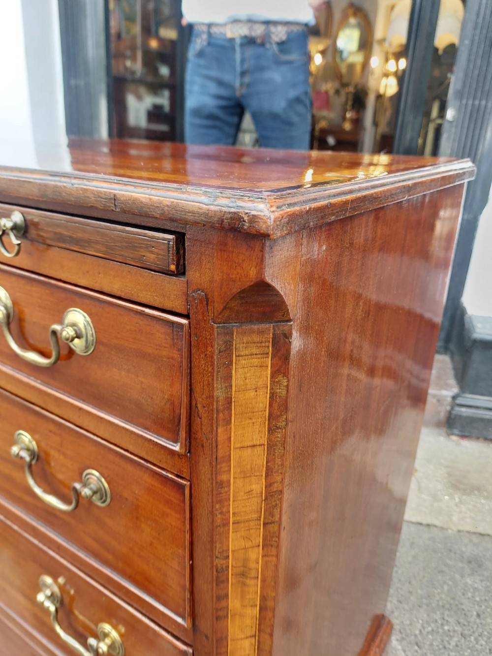 A George III mahogany bachelors chest featuring four graduated drawers, brass swan-neck handles, an upper pull-out brushing slide, and classic bracket feet. View VIII