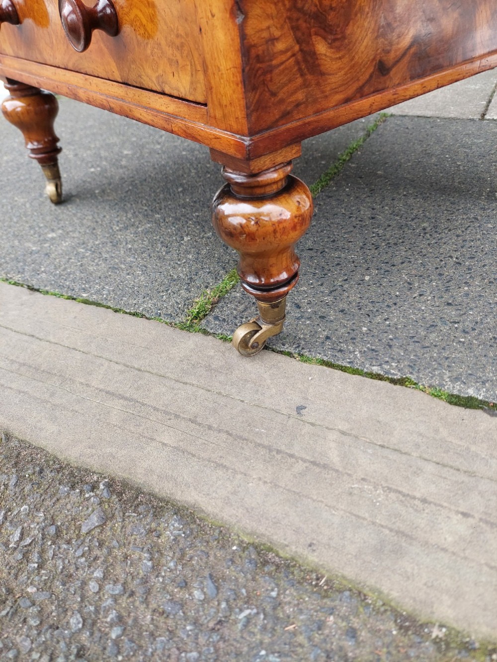 A High Victorian burr walnut Canterbury featuring four open compartments with fretwork dividers above a single drawer with turned legs on brass castors. View VIII