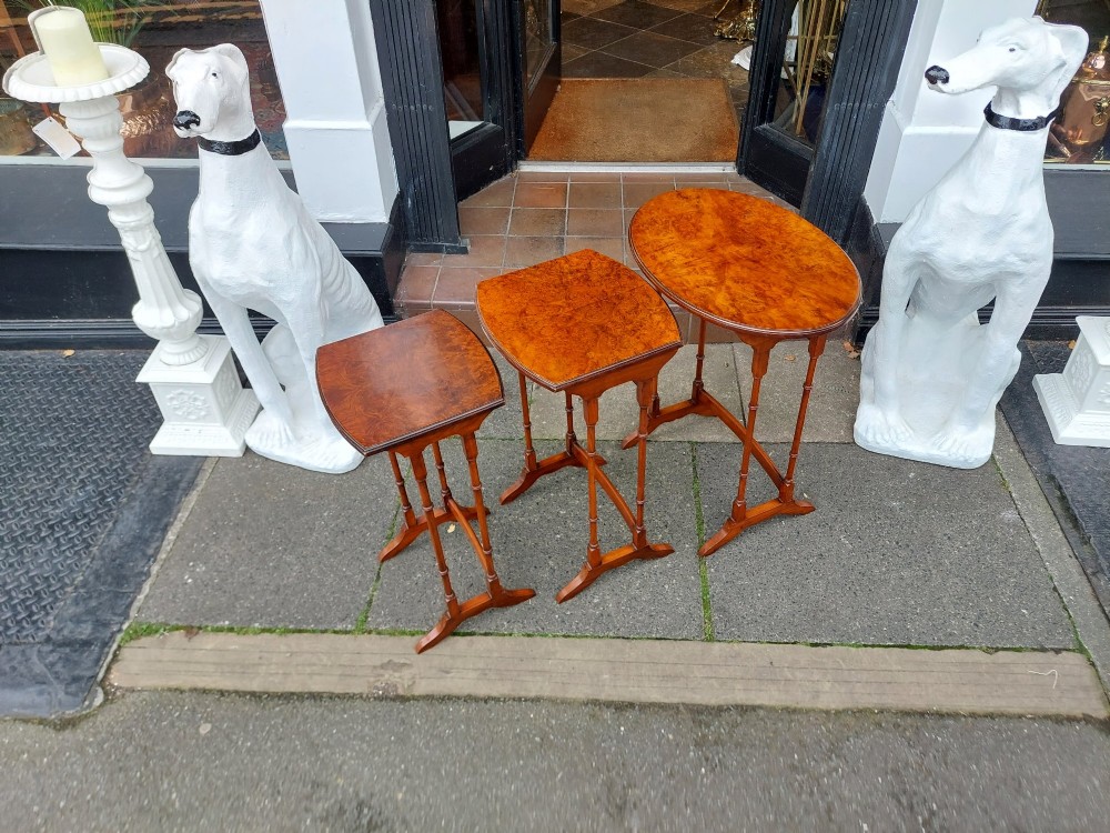 A set of three Edwardian nesting tables crafted from burr walnut with slender turned legs, stretcher supports, and shaped tops. View III